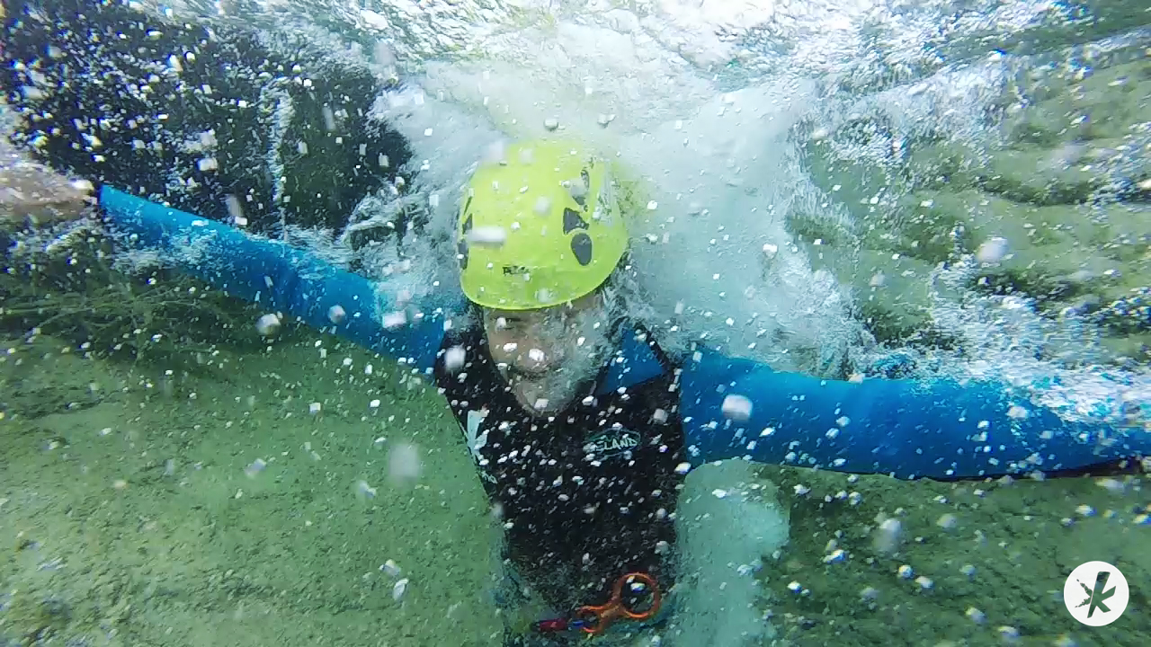 Persona buceando realizando coasteering